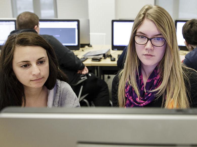 Two students working together in a computer lab